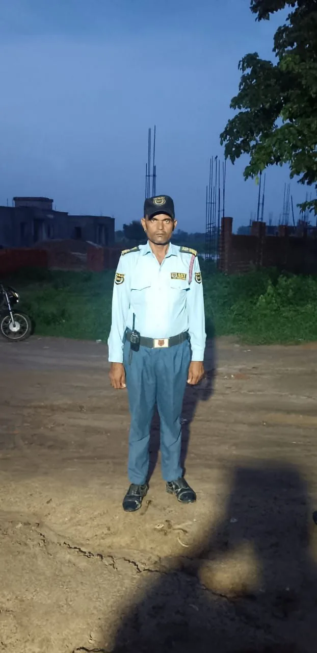 SST Security Agency guard standing at an outdoor site during dusk
