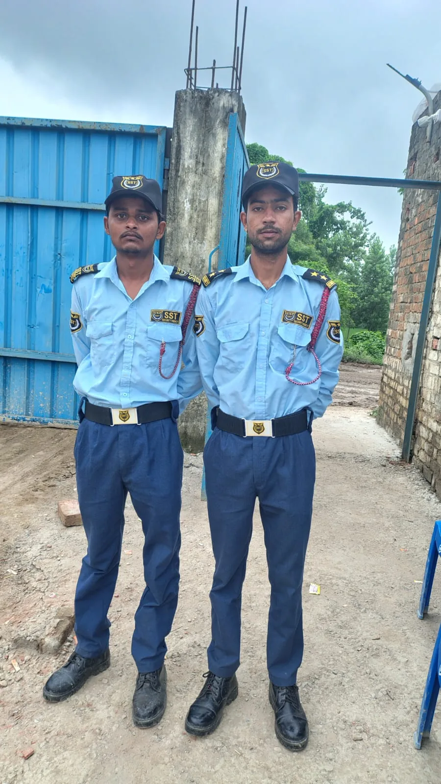 Two SST Security Agency guards in uniform at a work site